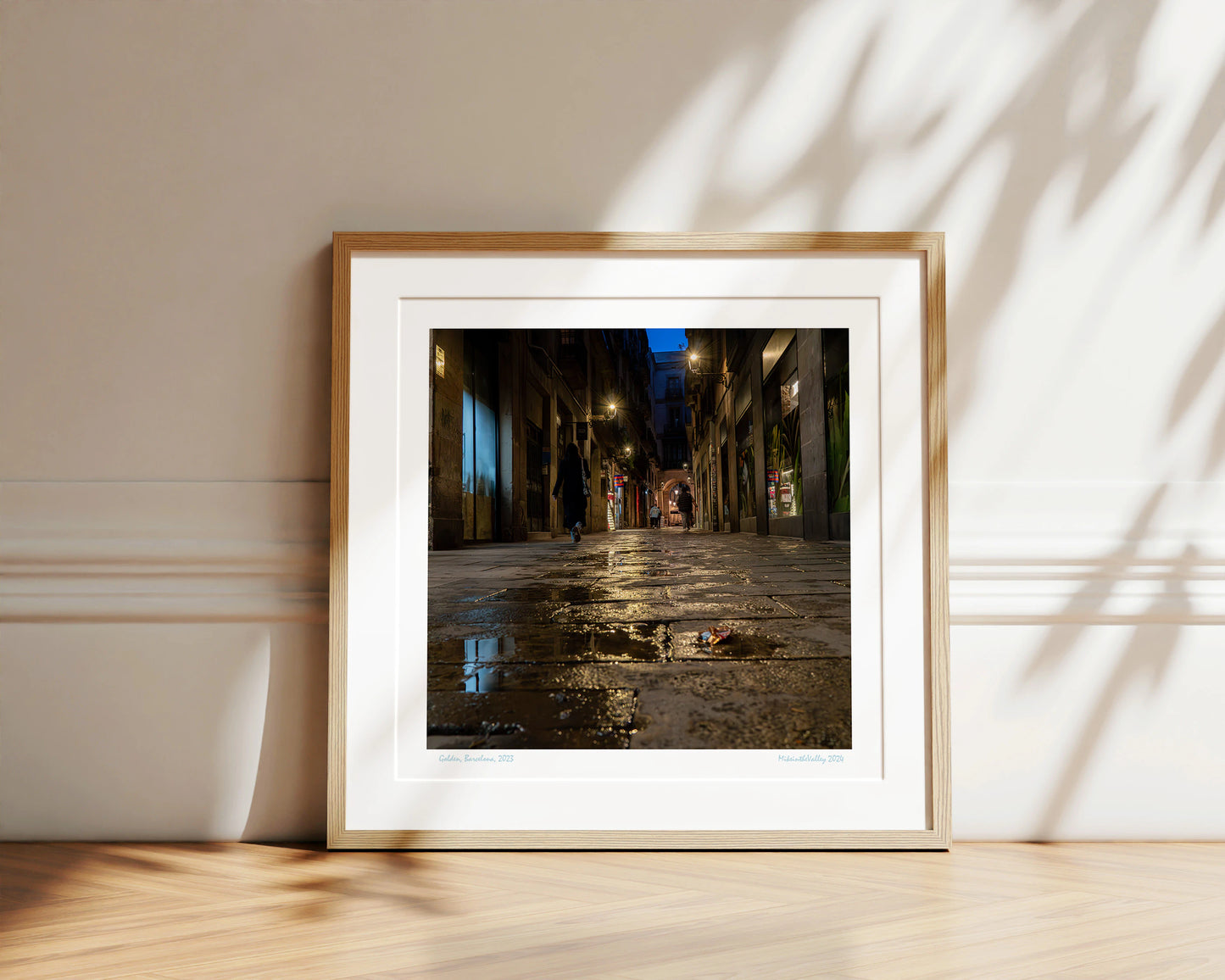 Gasse in Barcelona. Blaue Stunde. Wasserpfütze im Vordergrund. Mehrere Laternen mit Lichterkranz